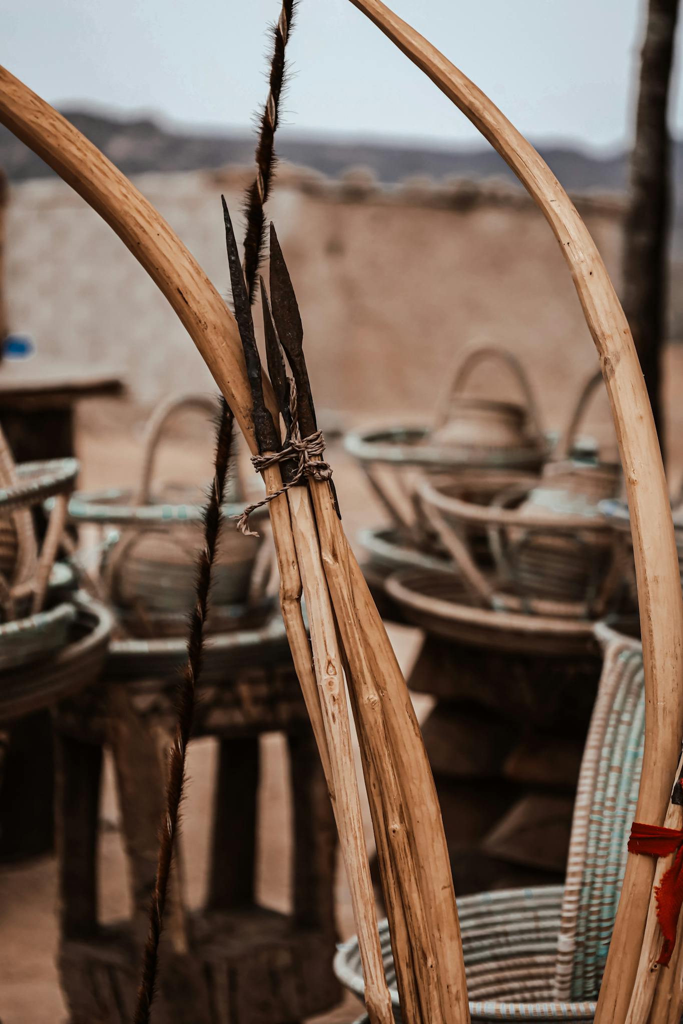 Rustic Angolan wicker baskets and tools in a rural setting, showcasing traditional craftsmanship.